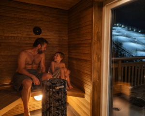 Pappa och son i bastun en vinterkväll